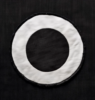 a cloth patch embroidered with a white circle an example of a circle with a white circle clip artwork, in the style of dark modernism, genderless, rectangular fields, fletcher sibthorp, ray collins, frank miller, gender-bending iconography