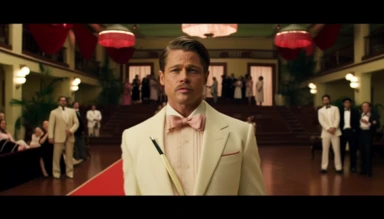 Brad Pitt as Aldo Raine from the movie Inglourious Basters in the style of the director Wes Anderson, full body shot, he is in the center of the photograph looking directly at the camera. He has a pencil moustache. He is wearing a white tuxedo jacket, black bow tie, red rose lapel clip, black pants. The background is the lobby of an art-decó movie theatre designed in the style of Wes Anderson in a Wes Anderson color palette, symmetrical, whimsical, ornate, planimetric composition,