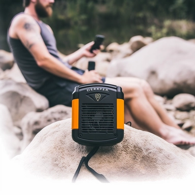 is a a tall by 4-inch wide personal portable fan and power bank. Imagine a dynamic and active scene. The Breeze EZ Portable Waist Clip Fan & Power Bank is being used by a hiker during a camping trip. The hiker is sitting on a log, taking a break from their journey. The fan is clipped to their belt, visibly providing a soothing breeze. The hiker's smartphone is connected to the fan, indicating the power bank feature. The scene is set in a lush forest with sunlight filtering through the trees. The